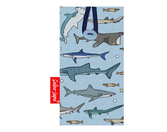 May include: A blue fabric pouch with a variety of sharks and fish printed on it. The pouch has a blue button closure and a red label that says "Selina-Jayne".