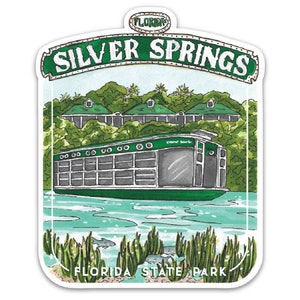 May include: A green and white sticker with an illustration of a boat on a river. The sticker says "Silver Springs Florida State Park" and has a green banner above the boat that says "Silver Springs".