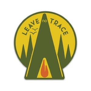 May include: Yellow and green sticker with a mountain silhouette and a campfire inside. The text "LEAVE no TRACE" is written around the mountain.