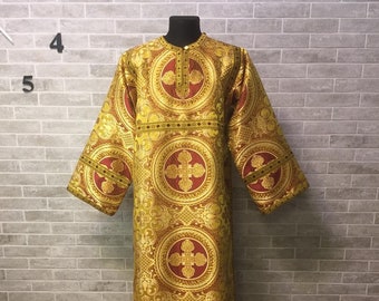 Puede incluir: Una túnica litúrgica dorada y roja con un patrón de cruz. La túnica está hecha de tejido brocado y tiene un cuello alto.