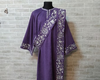 May include: A purple liturgical robe with silver embroidery of floral designs and geometric patterns. The robe is displayed on a mannequin.