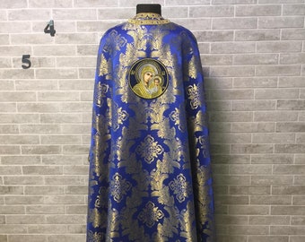 Puede incluir: Una vestimenta litúrgica azul y dorada con un icono bordado de la Virgen María y el Niño. La vestimenta está decorada con un patrón floral.