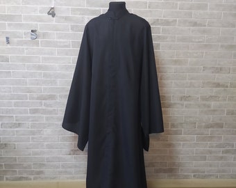 Może przedstawiać: Długa, czarna szata z wysokim kołnierzem i długimi rękawami. Szata wykonana jest z gładkiego materiału i ma prosty design.
