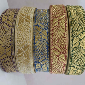Peut inclure: Cinq rouleaux de galon doré avec des fonds de couleurs différentes. Le galon présente un motif répétitif de feuilles et de raisins.