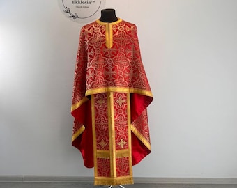 Może przedstawiać: Czerwona i złota szata liturgiczna z misternymi haftami. Szata jest wystawiona na stojaku. Tekst "Ekklesia™ Church Clothes" jest widoczny w lewym górnym rogu obrazu.