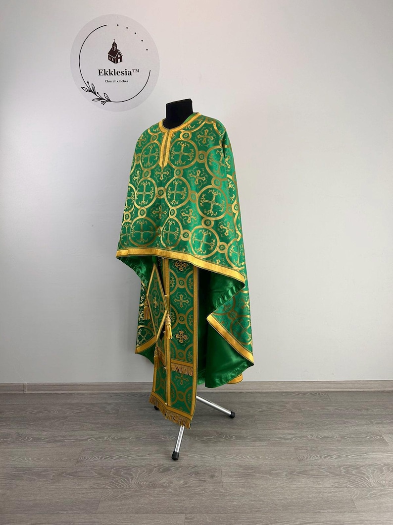 May include: A green liturgical vestment with gold embroidery, featuring a cross pattern. The vestment is displayed on a stand.