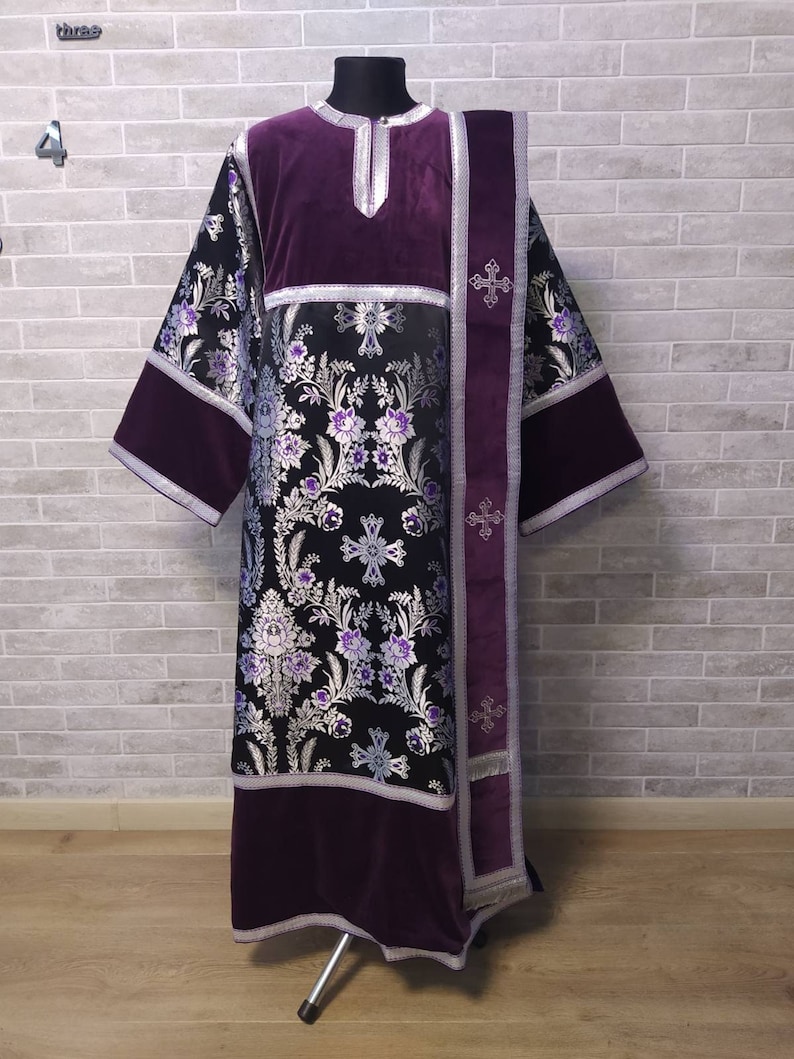 May include: A purple liturgical vestment with a black and silver brocade pattern and a matching purple stole. The vestment has a silver trim and a cross design.