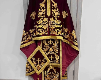 May include: Burgundy velvet liturgical vestment with gold embroidery of grapevines and crosses. The vestment includes a stole, a maniple, and a chasuble.