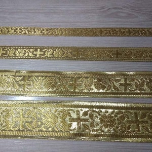 May include: Four gold-colored trims with a repeating pattern of crosses and floral designs. The trims are different widths and have varying levels of detail.