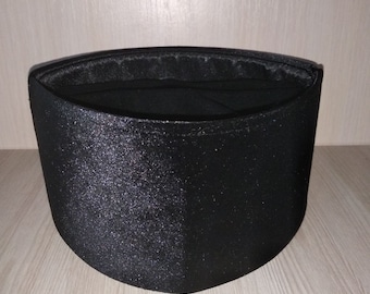 May include: A black, round, fabric hat with a smooth, shiny surface.