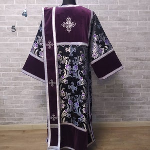 May include: A black and silver brocade liturgical vestment with purple velvet accents. The vestment features embroidered crosses and floral designs.