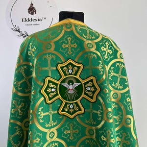 May include: Green liturgical vestment with a gold embroidered cross and a dove design. The vestment has a repeating pattern of crosses and circles.