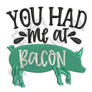 Può includere: Disegno ricamato con il testo "You had me at bacon" in nero con un piccolo cuore sopra la "u". Una silhouette di maiale verde si trova sotto il testo.