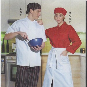 May include: Two chefs wearing white and red chef jackets with black and white striped pants and black pants. The chef on the left is holding a blue mixing bowl. The chef on the right is wearing a white apron with a black tie.