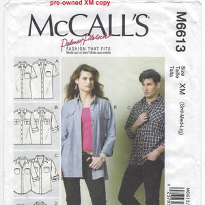 May include: A white ceramic mug with a black handle and the text "But First, Coffee" in a black, handwritten-style font. The mug is on a white surface.