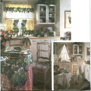 May include: A kitchen scene featuring a round table covered with a tablecloth displaying a grape and pink gingham pattern. A wooden chair with a floral cushion sits nearby. The window is dressed with matching grape-patterned curtains.
