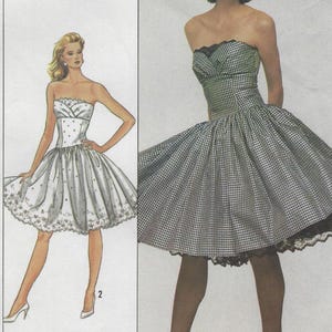 May include: A vintage sewing pattern featuring two strapless dresses. One dress is white with polka dots and floral embroidery. The other is a black and white gingham pattern with a black lace hem. The pattern is labeled "belle france".