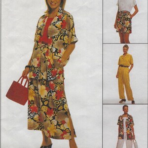 May include: A woman wearing a floral print outfit, including a short-sleeved jacket, a long skirt with a side slit, and black heels. She carries a red handbag. The outfit features a pattern of red, yellow, and brown flowers on a black background.