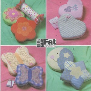 May include: A collection of fabric-covered padded shapes labeled with letters A through I, including hearts, flowers, butterflies, a star, and a cylinder. The items feature various floral, plaid, and polka dot patterns. The text Fat Quarters is visible.
