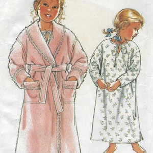 May include: Illustration of two children's sleepwear designs. One child wears a pink robe with lace trim and a belt. The other child wears a white nightgown with a blue floral pattern. Both designs have a vintage aesthetic.