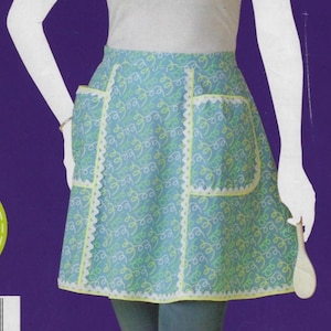 May include: A blue and white apron with a scalloped edge and two pockets. The apron has a pattern of yellow and green swirls.