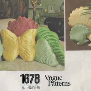 May include: A collection of decorative pillows in various shapes, including a butterfly, leaves, and seashells. The pillows are in shades of yellow, green, and pink. The image also includes the text "1678 Vogue Patterns".