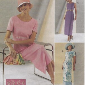 May include: A sewing pattern illustration featuring three dress variations. View A is a pink short-sleeved dress with white embroidery, paired with a matching hat. View B is a floral print dress with a blue hat. View C is a purple sleeveless dress.