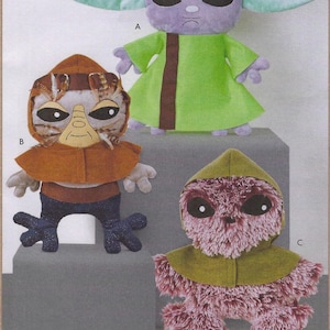 May include: Three plush alien toys. The top alien is purple with large ears and a green robe. The middle alien has a brown hood and face. The bottom alien is pink with a green hood. The text at the bottom reads "18" PLUSH ALIENS".