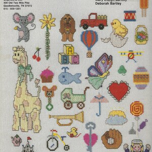 May include: A collection of 30 mini cross stitch patterns for baby and children's clothing. The patterns include a giraffe, a heart, a butterfly, a truck, a hot air balloon, a cupcake, a baby carriage, a castle, a rocket, a key, a rainbow, a drum, a chick, a mouse, a dog, a fish, a trumpet, a tricycle, a sun, a lollipop, a teddy bear, a  letter block, a  clover, an egg, a  basket, an umbrella, and a  girl in a sailor outfit.