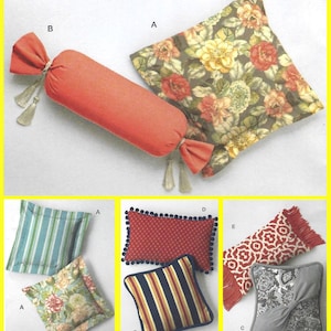 May include: A collection of various throw pillows including a coral candy-shaped bolster with tassels, a floral square pillow, a blue striped square pillow, a red patterned rectangular pillow with pom-poms, and a gray textured square pillow.