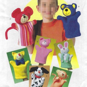 May include: A collection of seven colorful animal hand puppets including a red mouse, blue bear, pink pig, yellow cat with a blue bow tie, white and black spotted dog, peach monkey, and white rabbit with green overalls, labeled Soft Stuff.