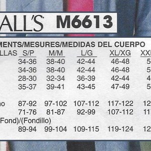 May include: A white ceramic mug with a black handle and the text "But First, Coffee" in a bold, black font. The mug is sitting on a wooden surface. The mug is 4 inches tall.