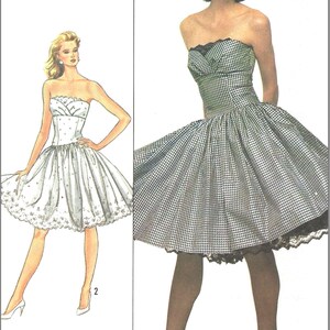 May include: A sewing pattern for a strapless dress by Jane Schaffhausen Belle France. The pattern features two views: a black and white gingham dress with a lace-trimmed hem and a white dress with a dotted pattern and a scalloped hemline.