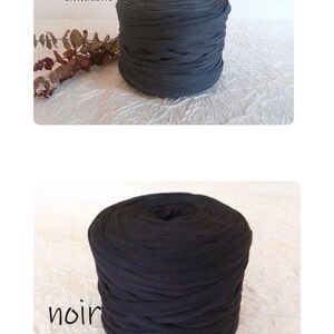 May include: Two spools of thick, dark gray and black fabric yarn. The top spool is labeled "gris anthracite" and the bottom spool is labeled "noir". The yarn is tightly wound, and the texture appears soft and pliable.