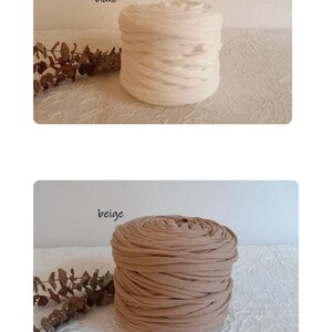 May include: Two spools of fabric, one white and one beige, are displayed. The white spool is labeled "blanc" and the beige spool is labeled "beige". The fabric is tightly wound, creating a cylindrical shape. The background is a textured white surface.