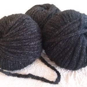 Puede incluir: Tres ovillos de hilo negro con hilo de purpurina plateado. El hilo es suave y esponjoso.