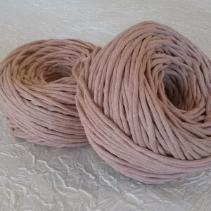 Peut inclure: Deux bobines de corde en coton &eacute;paisse de couleur rose clair. La corde est enroul&eacute;e &eacute;troitement autour d'elle-m&ecirc;me, cr&eacute;ant une forme circulaire.