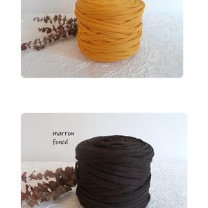 May include: Two spools of fabric yarn are displayed. One is a golden yellow color, labeled "safran". The other is a dark brown color, labeled "marron fonc&eacute;". Both spools are cylindrical and sit on a white textured surface.