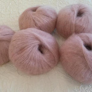 May include: Five balls of pale pink yarn, likely mohair or a similar soft fiber.