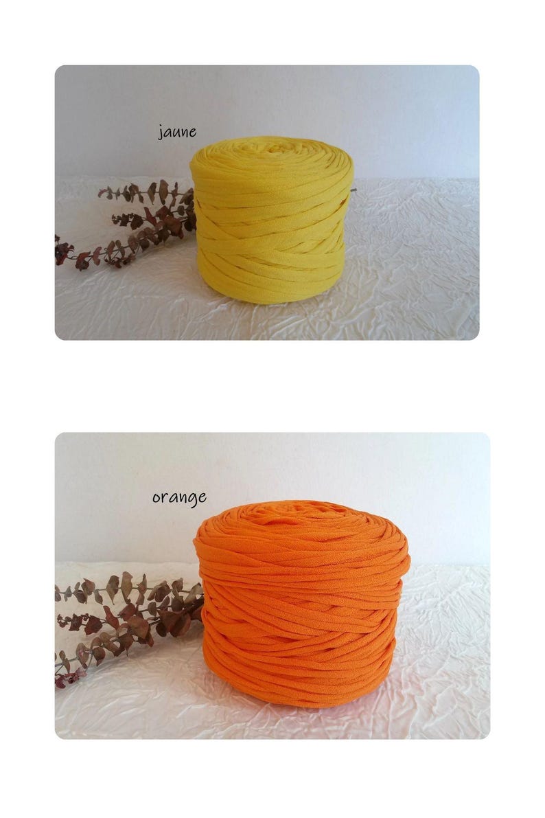 May include: Two spools of fabric yarn, one yellow and one orange, are displayed. The yellow spool is labeled "jaune" and the orange spool is labeled "orange". The yarn is tightly wound, and the spools are cylindrical.