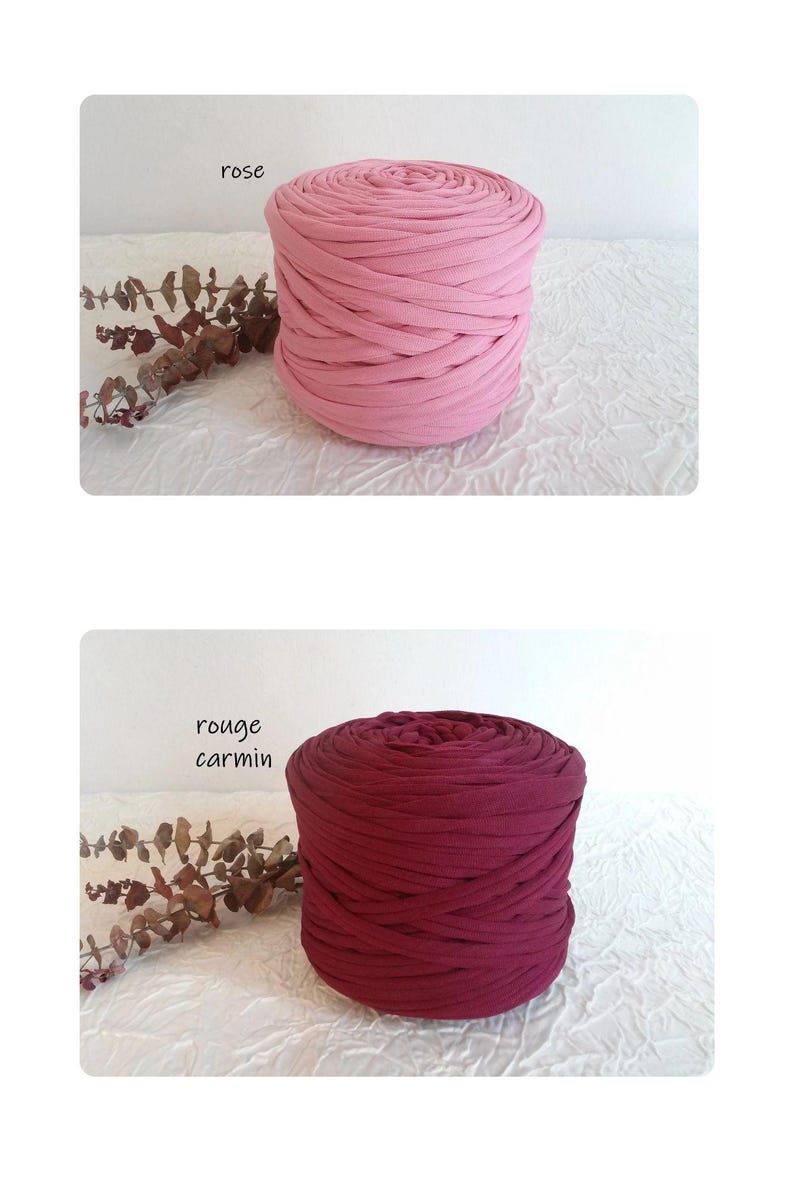 May include: Two spools of thick, knitted fabric in shades of pink and burgundy. The top spool is a light pink, labeled "rose", and the bottom spool is a deep burgundy, labeled "rouge carmin". Both are on a white textured surface.