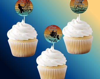 Puede incluir: Tres cupcakes con glaseado blanco y adornos con temática de pesca. Los adornos tienen texto que dice "Happy Birthday Dad" y "Reel Cool Dad". Los cupcakes están en envoltorios de papel acanalado marrón claro.
