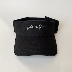 May include: Black visor with the word "grandpa" embroidered in white on the front.