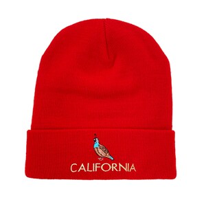 May include: Red knit beanie with a brown and blue embroidered quail and the word "CALIFORNIA" in gold thread.