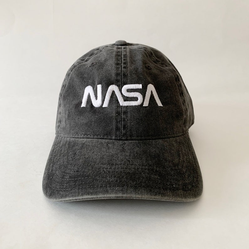 May include: A black, distressed, cotton baseball cap with a white embroidered NASA logo.
