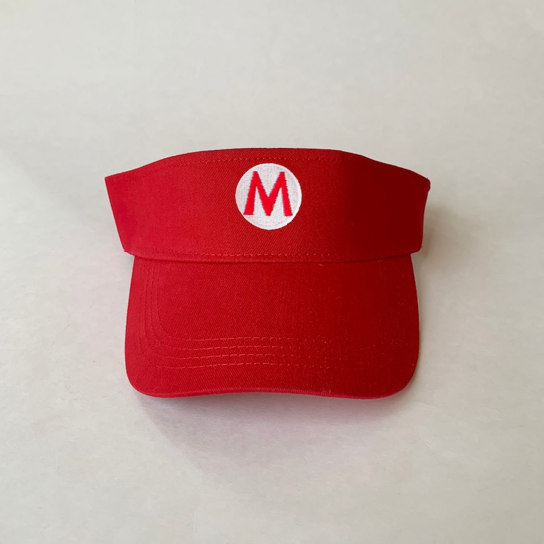 Op de afbeelding: Rode visor met een witte cirkel en een rode "M" in het midden.