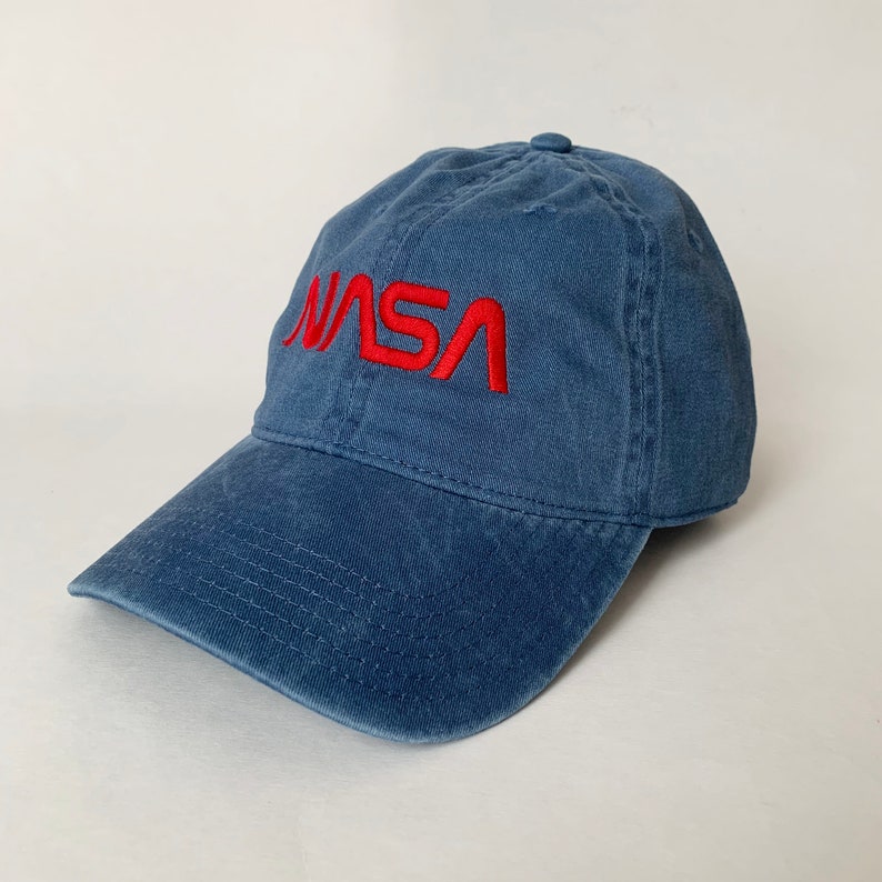 May include: A blue denim baseball cap with a red embroidered NASA logo.