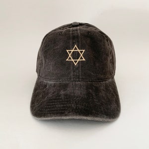 May include: A black baseball cap with a gold embroidered Star of David.