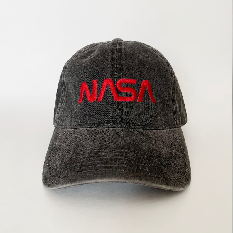 May include: A black distressed baseball cap with a red embroidered NASA logo.