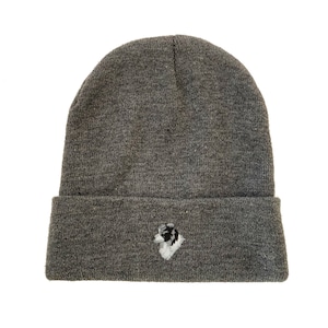May include: Gray knit beanie with a white embroidered border collie dog head on the front.